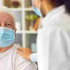 Elderly Patient And Healthcare Professional Wearing Masks